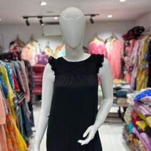 A black sleeveless dress with a pleated yoke and ruffle straps